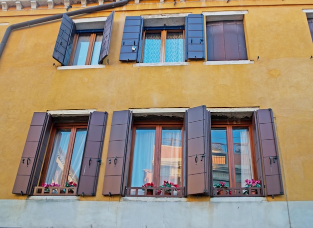 Braune Fenster in einer gelben Wand