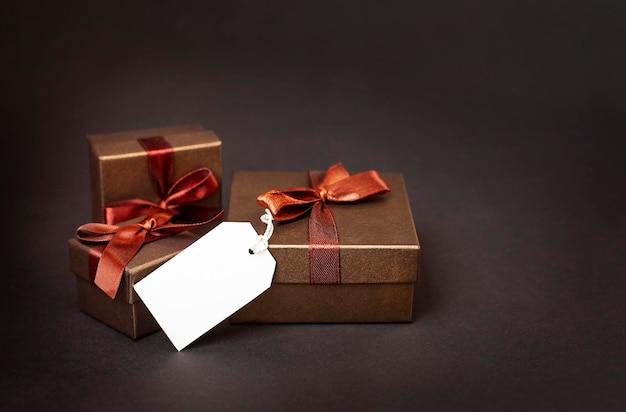 Braune Geschenkboxen mit weißem Etikett hautnah auf schwarzem Hintergrund