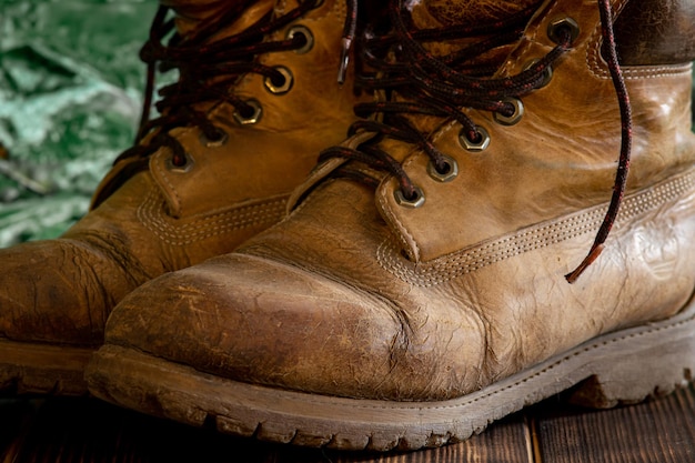 Braune Schuhe der alten schäbigen Männer auf einem unscharfen grünen Hintergrund