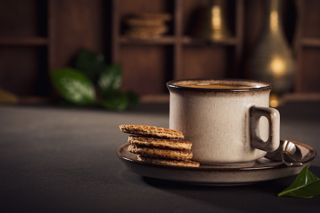 Braune Tasse Kaffee und niederländische traditionelle Stroopwafels. Lebensmitteloberfläche mit Kopierraum