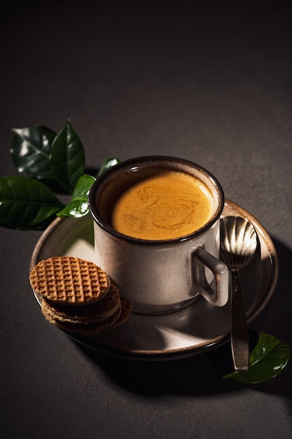 Braune Tasse Kaffee und niederländische traditionelle Stroopwafels. Lebensmitteloberfläche mit Kopierraum