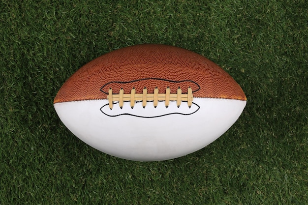 brauner American-Football-Ball aus Leder auf dem Rasen