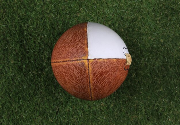 brauner American-Football-Ball aus Leder auf dem Rasen