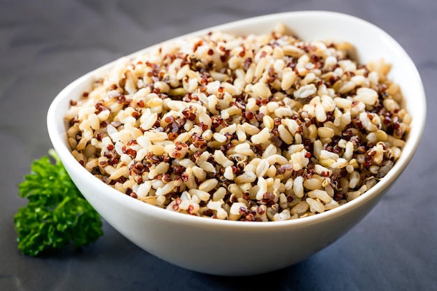 Foto brauner reis und quinoa in weißer schüssel auf schiefer