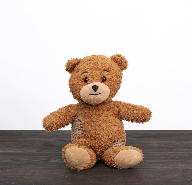 Brauner Teddybär, der auf einem braunen Holztisch sitzt