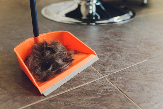 Braunes Männerhaar mit grauem Haar. Kurz geschnittene Schlösser befinden sich auf hellem Keramikboden.