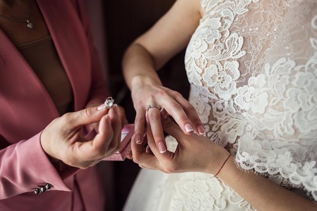 Braut am Hochzeitstag hält die Hände ihrer Mutter und legt den Ring auf den Finger Konzept der Beziehung zwischen Müttern und Töchtern