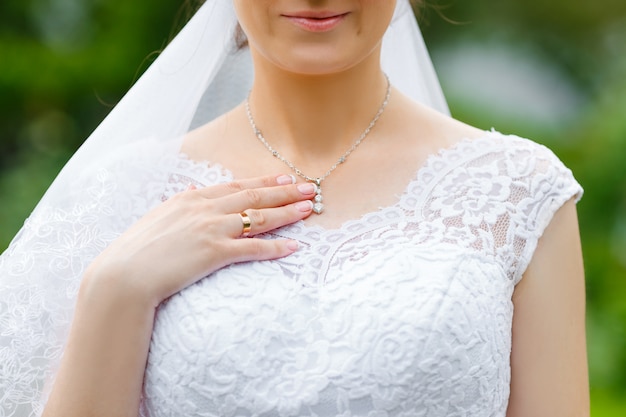 Braut berührt glänzenden Diamantanhänger