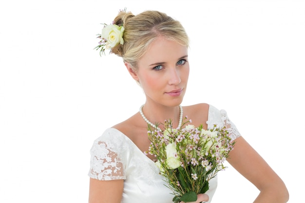 Braut, die Blumenstrauß gegen weißen Hintergrund hält