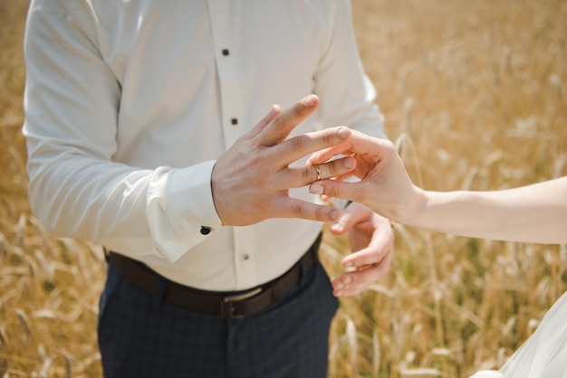 Braut, die dem Finger des Bräutigams einen Ehering anlegt. Hochzeitstag .