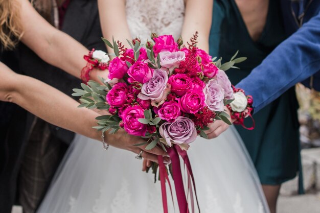 Braut, die einen Hochzeitsblumenstrauß in einem Kleid hält