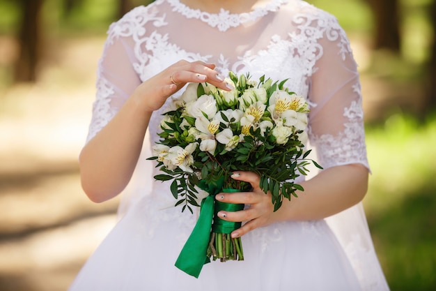 Braut, die Hochzeitsstrauß von frischen Blumen, grüne Hochzeit hält