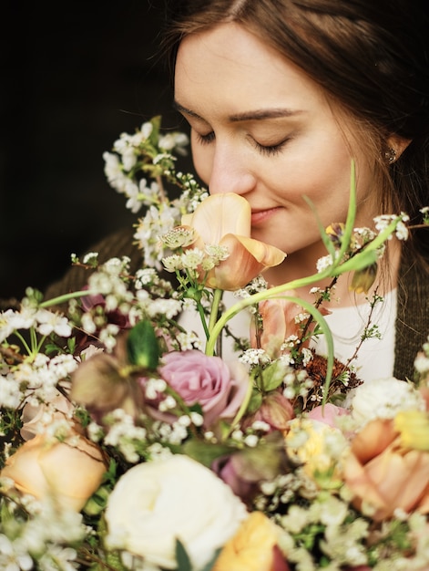 Braut hält einen Hochzeitsblumenstrauß und schnüffelt Blumennahaufnahme, großen schönen Blumenstrauß