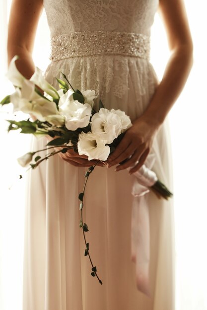 Braut hält in ihrem Handblumenstrauß von weißen Blumen