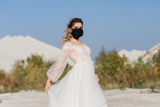 Braut im Hochzeitskleid mit medizinischer Maske