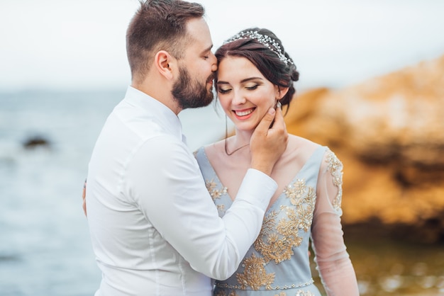 Braut in einem blauen Kleid geht am Meer entlang