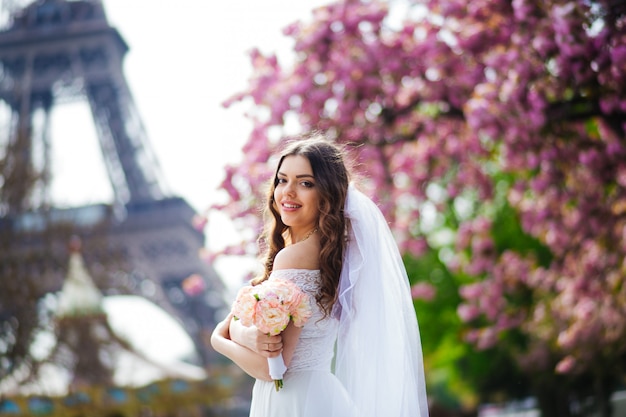 Braut in Paris, weißes Kleid tragend einen Blumenstrauß