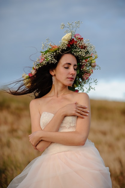 Braut mit Blumenkranz auf dem Kopf in der Natur