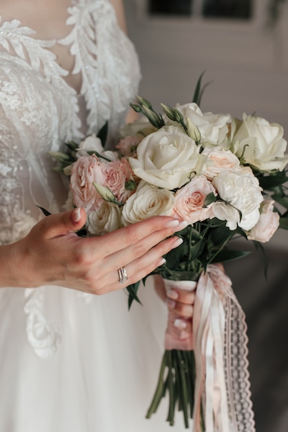 Braut mit Blumenstrauß, weißer Rose, Maniküre, weißem Kleid