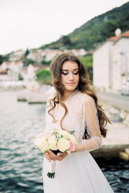 Braut mit einem Rosenstrauß in ihren Händen am Ufer von Perast