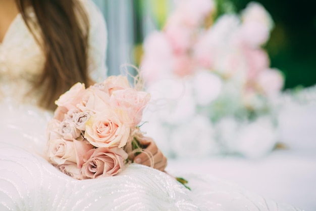 Braut nahe Hochzeitsbogen mit Blumen