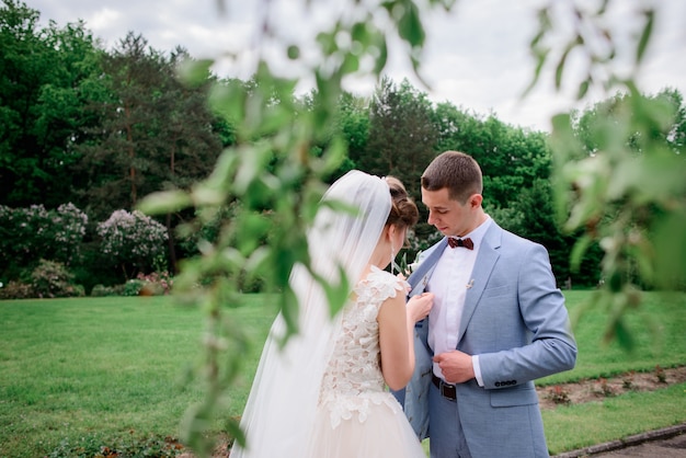 Braut pins boutonniere, um die Jacke des Bräutigams zu bürsten