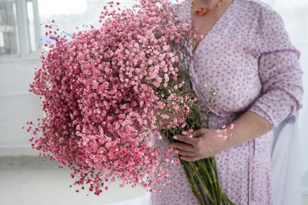 Braut plus Größe hält Blumenstrauß rosa gipsofila