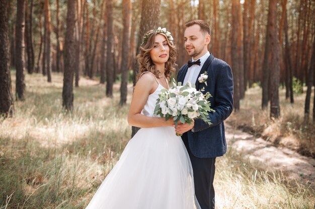 Braut und Bräutigam am Hochzeitstag draußen gehend auf Sommernatur