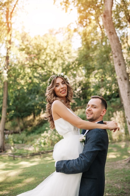 Braut und Bräutigam am Hochzeitstag draußen gehend auf Sommernatur