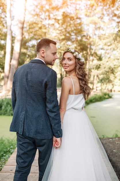 Braut und Bräutigam am Hochzeitstag draußen gehend auf Sommernatur