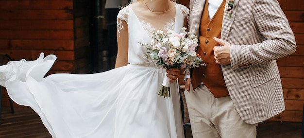 Braut und Bräutigam am Hochzeitstag umarmen und zeigen Liebe mit einem Hochzeitsstrauß aus Rosenblüten