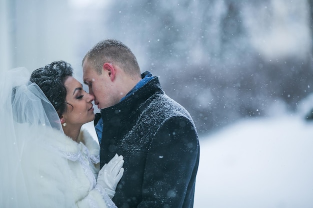 Braut und bräutigam, die auf die europäische stadt im schnee gehen