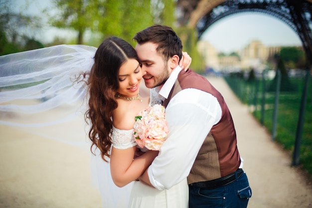 Braut und Bräutigam, die einen romantischen Moment an ihrem Hochzeitstag in Paris haben