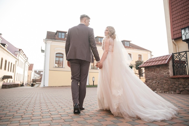 Braut und Bräutigam gehen die Straße der Altstadt entlang. Feiertage und Veranstaltungen