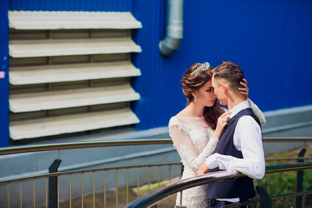 Braut und Bräutigam gehen in der Stadt, Hochzeitstag, Ehekonzept. Braut und Bräutigam im städtischen Hintergrund. junges Paar, das am Hochzeitstag auf einer Treppe geht.