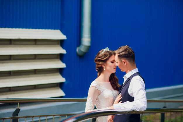 Braut und Bräutigam gehen in der Stadt, Hochzeitstag, Ehekonzept. Braut und Bräutigam im städtischen Hintergrund. junges Paar, das am Hochzeitstag auf einer Treppe geht.