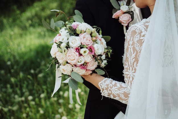 Foto braut und bräutigam halten einen hochzeitsblumenstrauß 1