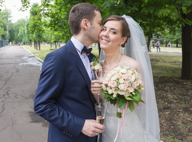 Braut und Bräutigam küssen sich im Park