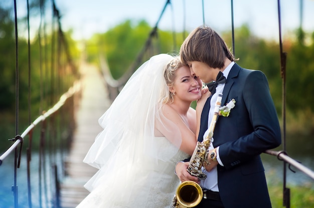 Braut und Bräutigam mit Sax stehen auf der Brücke