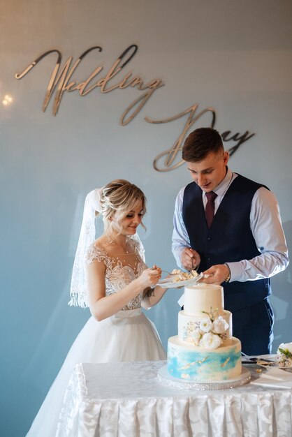 Foto braut und bräutigam schneiden und probieren hochzeitskuchen