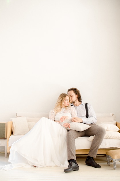 Braut und Bräutigam sitzen auf einem Sofa