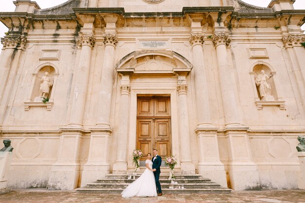 Braut und Bräutigam stehen in der Nähe der Tür auf der Treppe der Geburt der seligen Jungfrau