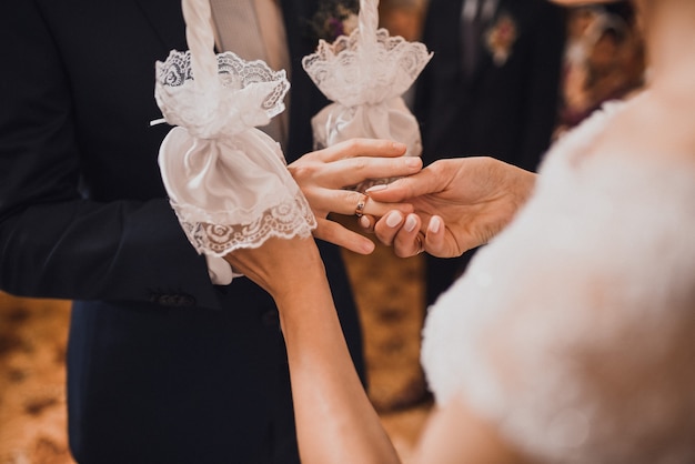 Braut und Bräutigam tauschen Ringe aus. Ein Mann legt einer Frau einen Ehering auf die Hand