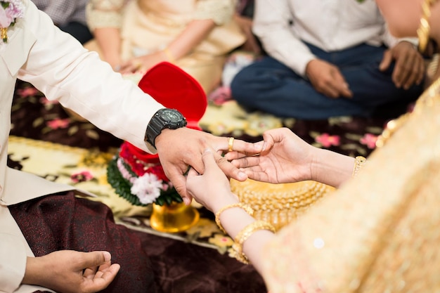 Braut und Bräutigam tauschen während der Hochzeit vor Menschen Ringe aus