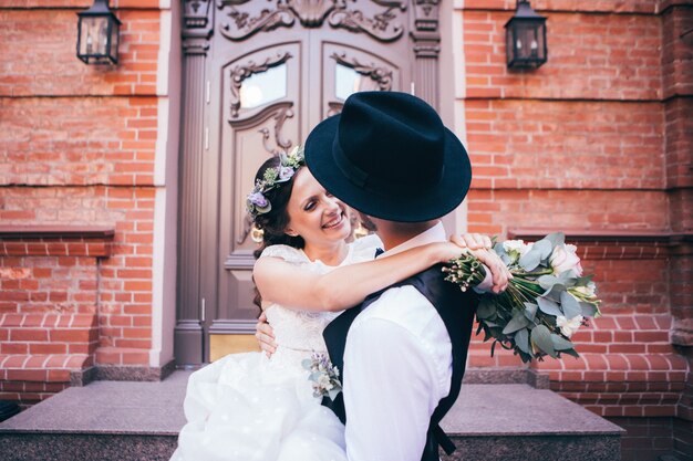 Braut und Bräutigam umarmen am Hochzeitstag, glückliches junges Paar, das im Park in der Natur, Valentinstag küsst