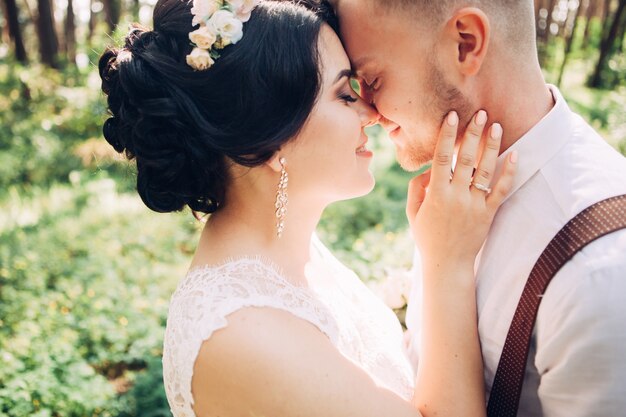 Braut und Bräutigam umarmen am Hochzeitstag, glückliches junges Paar, das im Park in der Natur, Valentinstag küsst