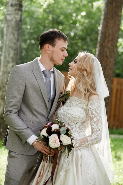 Braut und Bräutigam umarmen, schöne Hochzeit in der Natur. Liebevolles junges Paar