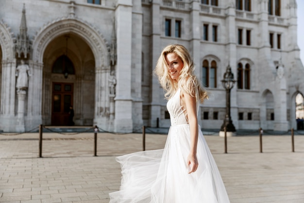 Braut und Bräutigam umarmen sich in der Altstadtstraße. Hochzeitspaar verliebt. Luxus Strass Kleid.