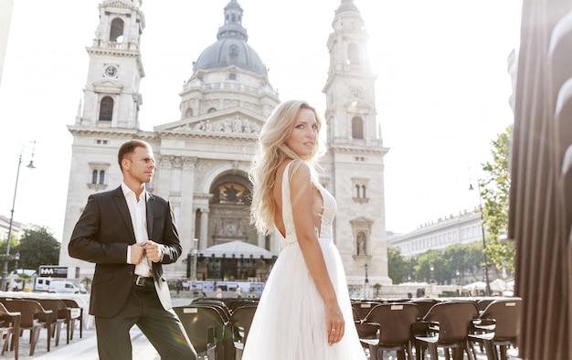 Braut und Bräutigam umarmen sich in der Altstadtstraße. Hochzeitspaar verliebt. Luxus Strass Kleid.