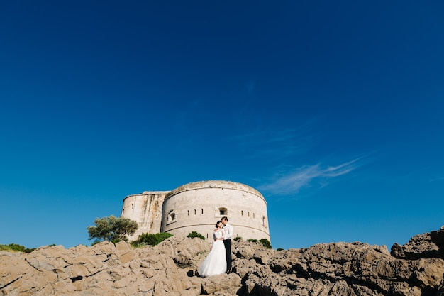 Braut und Bräutigam umarmen sich in der Nähe der Festung Arza auf der Insel Mamula.